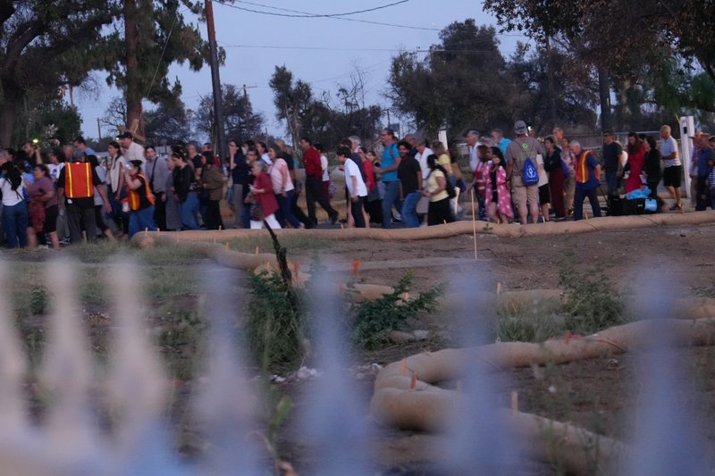 Hundreds participating in the National Eucharistic Pilgrimage procession through the streets of Altadena near Sacred Heart Church on June 20, 2025 passed several empty lots that once contained the homes burned down in the Eaton Fire. (Katie Trejo)