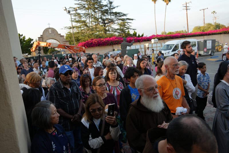 A crowd follows the Eucharistic procession at Mission San Gabriel Arcángel on June 21 as part of the National Eucharistic Pilgrimage. (Katie Trejo)