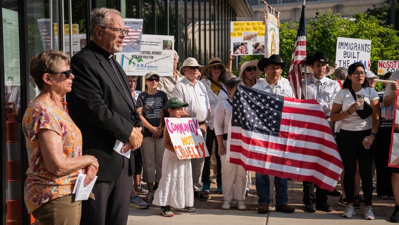 Judith Brooks, president of the Detroit-based immigrants' rights grassroots organization Strangers No Longer, and Father David Buersmeyer, the group's chaplain, address nearly 250 people of various faiths who took part in a solemn procession July 14, 2025, to the U.S. Immigration and Customs Enforcement's Detroit Field Office. (OSV News photo/Valaurian Waller, Detroit Catholic)