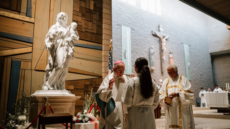 Archbishop José H. Gomez stands in front of the Mary, Mother of Fairest Love statue as he helps consecrate the faithful to the Blessed Mother at St. Louise de Marillac Church in Covina on June 26. (Peter Lobato)