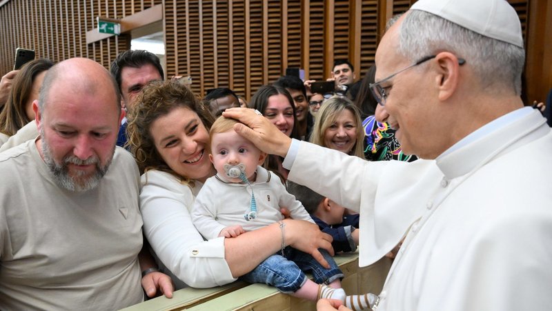 Pope Leo XIV greets a child during a meeting with officials and employees of the Roman Curia, Vatican City State and the Diocese of Rome in the Paul VI Audience Hall at the Vatican May 24, 2025. (CNS photo/Vatican Media)