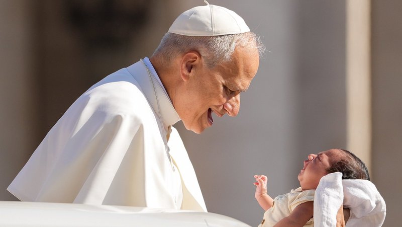 Pope Leo XIV greets a baby from the popemobile as he rides around St. Peter's Square at the Vatican before his weekly general audience June 25, 2025. (CNS photo/Lola Gomez)