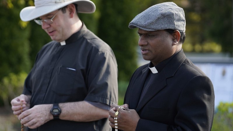 Fathers Charles Gnanapragasam, right, and Thomas Pers participate in a "Keep Our Priests" rosary rally at St. Mary Church in East Islip, N.Y., April 29, 2024. More than 300 people gathered to pray for changes in U.S. immigration procedures to prioritize visa and green card applications for foreign-born religious workers, many of whom are being forced to leave the country because of federal delays in processing immigration paperwork. (OSV News photo/Gregory A. Shemitz)