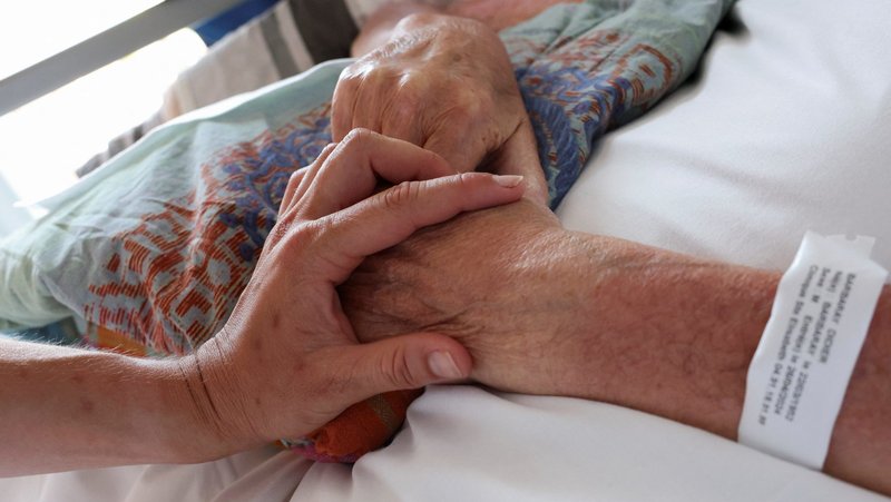 A nurse touches the hand of a patient in the palliative care unit of the Clinic Saint-Elisabeth in Marseille, France, May 31, 2024. In an Aug. 13, 2025, statement The Uruguay bishops' conference expressed sadness after the country's lower house of Congress approved a bill decriminalizing euthanasia. (OSV News photo/Manon Cruz, Reuters)