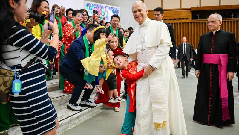 Pope Leo XIV greets children and families in traditional attire during his weekly general audience in the Paul VI Audience Hall at the Vatican Aug. 27, 2025. (CNS photo/Vatican Media)