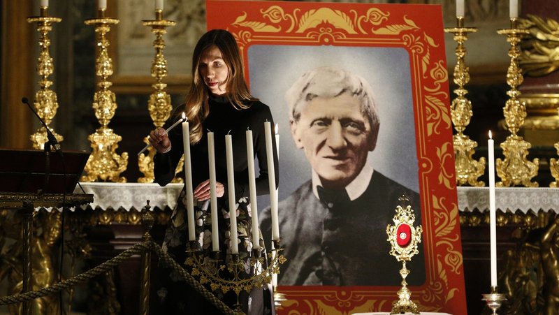 Melissa Villalobos of Chicago lights a candle during a vigil in advance of the canonization of St. John Henry Newman, at the Basilica of St. Mary Major in Rome Oct. 12, 2019. Villalobos' healing through the intercession of St. John Henry Newman was accepted as the miracle needed for the British cardinal's canonization. (CNS photo/Paul Haring)