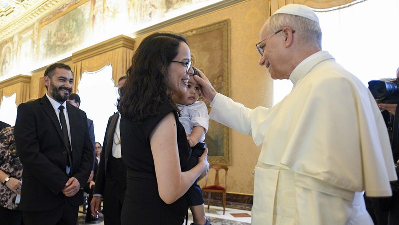 Pope Leo XIV blesses the child of a participant in a reflection on "the future of life and the family" in Latin America during an audience at the Vatican Sept. 19, 2025. (CNS photo/Vatican Media)