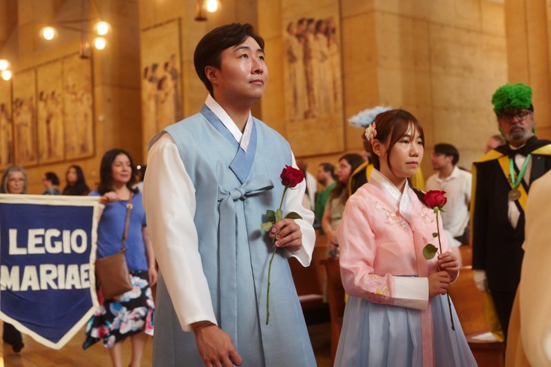 Attendees carry flowers to place in front of the Virgin Mary statue during the “One Mother, Many Peoples” Mass at the Cathedral of Our Lady of the Angels on Sept. 6, which celebrated the diverse cultures, organizations, and ethnic ministries in the Archdiocese of Los Angeles. (Reese Cuevas/Archdiocese of Los Angeles)