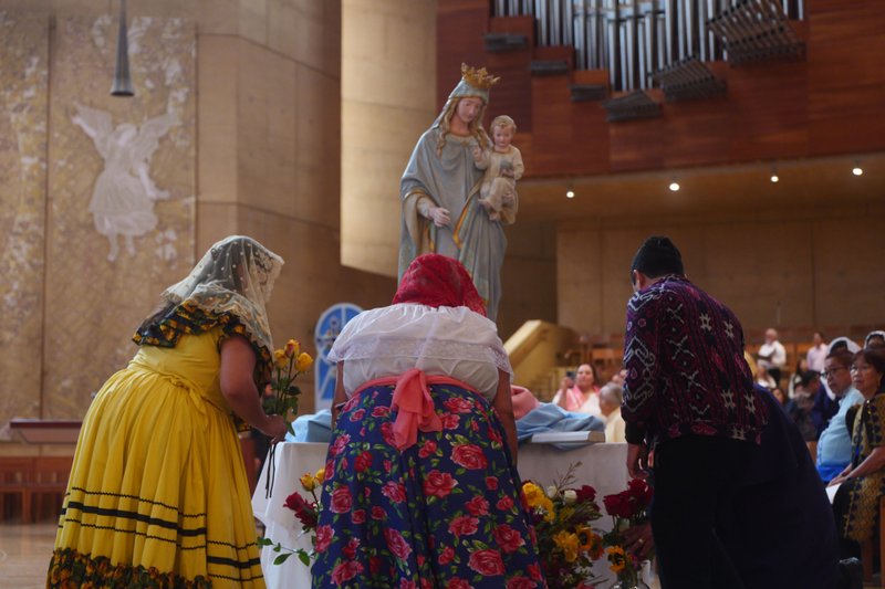 Attendees lay flowers in front of the Virgin Mary statue during the “One Mother, Many Peoples” Mass at the Cathedral of Our Lady of the Angels on Sept. 6, which celebrated the diverse cultures, organizations, and ethnic ministries in the Archdiocese of Los Angeles. (Reese Cuevas/Archdiocese of Los Angeles)