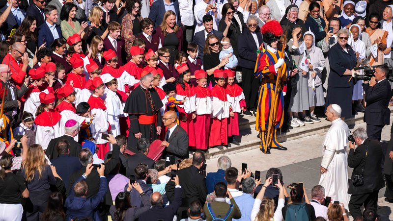 Pope Leo XIV approaches to greet Cardinal Blase J. Cupich of Chicago and students from Our Lady of Mount Carmel Academy in Chicago dressed as cardinals and a pope at the end of his weekly general audience in St. Peter’s Square at the Vatican Oct. 8, 2025. The students had captured worldwide attention when they held a mock conclave at their school May 6, electing their own “pope,” fourth grader Augie Wilk, who took the name “Pope Augustine,” just days before the election of Pope Leo, a fellow Chicagoan and Augustinian. (CNS photo/Lola Gomez)