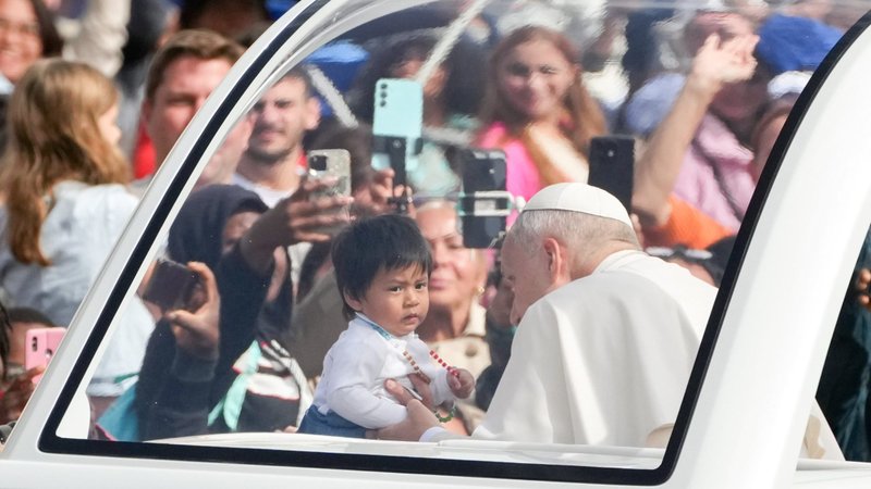 Pope Leo XIV greets a child from the popemobile as he rides around St. Peter’s Square following Mass for the Jubilee of Migrants and the Jubilee of the Missions in St. Peter's Square at the Vatican Oct. 5, 2025. (CNS photo/Lola Gomez)