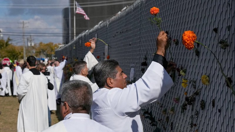 Religious leaders place marigold flowers used on the altar during the service into the fence surrounding the Broadview ICE facility in Chicago on the day an outdoor Mass observed by interfaith leaders, community members, and volunteers, after U.S. President Donald Trump ordered an increased federal law enforcement presence to assist in crime prevention. The Mass was led by Chicago Auxiliary Bishop José María Garcia-Maldonado. (OSV News photo/Leah Millis, Reuters)
