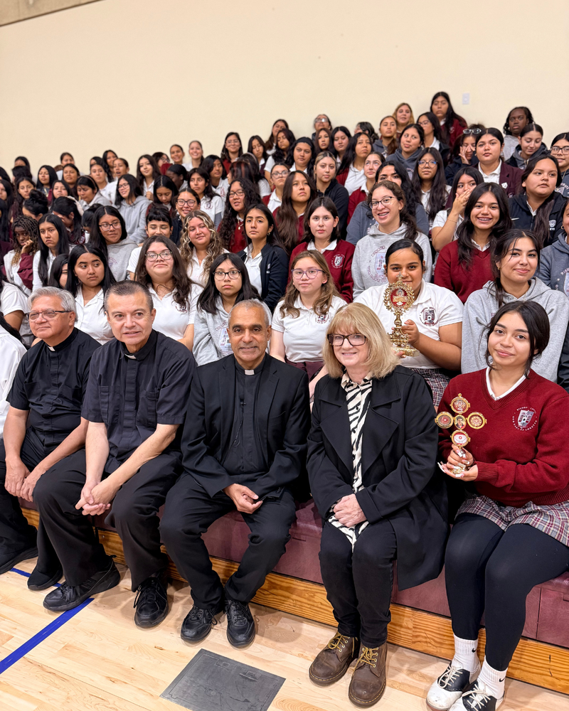 Msgr. Anthony Figueiredo, front center, Father Mario Torres, center left, and Father Michael Semana, far left, pose with Principal Robyn Carroll and students with the relics of St. Carlo Acutis at Bishop Conaty - Our Lady of Loretto High School on Oct. 21 during a tour of the saint's relics. (Bishop Conaty - Our Lady of Loretto High School)