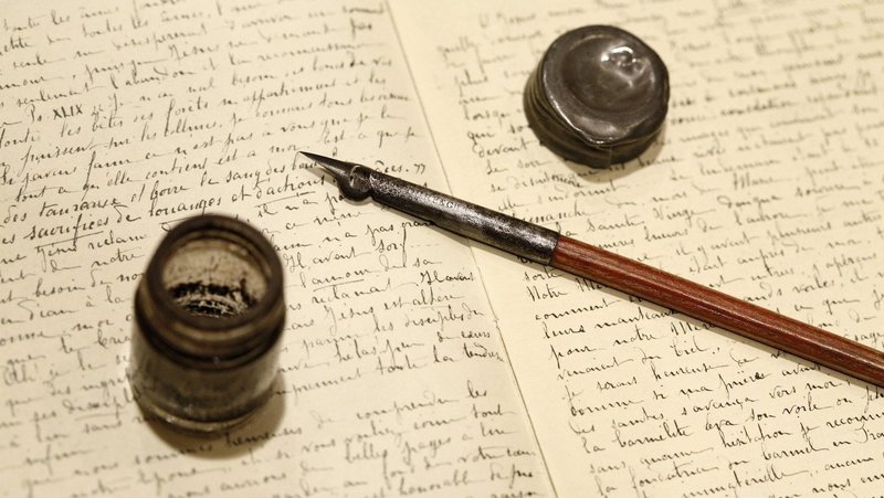 The pen and inkwell used by St. Therese of Lisieux rests on a facsimile of handwritten pages from the saint's “Story of a Soul.” (CNS/Nancy Phelan Wiechec)