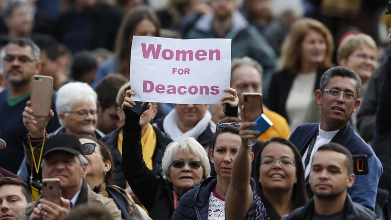A woman holds a sign in support of women deacons as Pope Francis leads his general audience in St. Peter's Square at the Vatican Nov. 6, 2019. (CNS/Paul Haring)