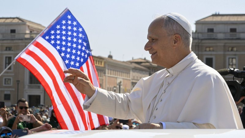 With a U.S. flag in the background, Pope Leo XIV waves to the crowd from the popemobile as he rides around St. Peter's Square at the Vatican before his weekly general audience Aug. 6, 2025. (CNS photo/Vatican Media)