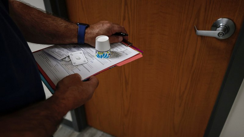 A doctor carries mifepristone, the first of two drugs used either in a medication-based abortion or in some miscarriage care protocols, to a patient waiting in an exam room at Alamo Women's Clinic in Carbondale, Ill., April 20, 2023. (OSV News photo/Evelyn Hockstein, Reuters)