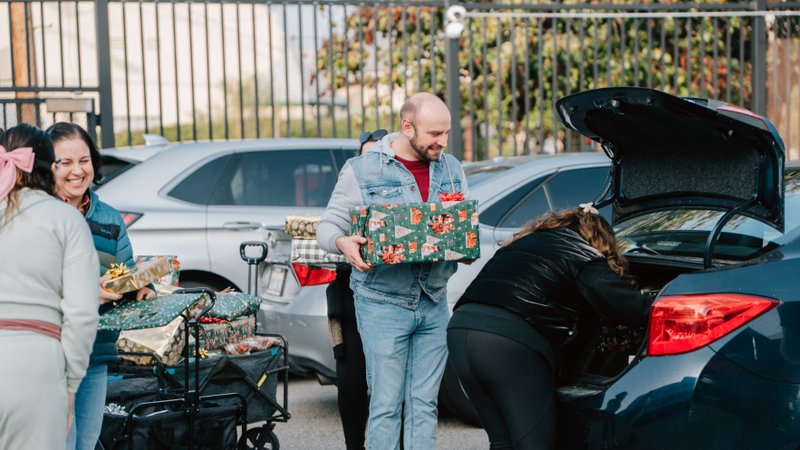 Volunteers carry donations of gifts, clothing, and more during the annual Adopt-a-Family LA distribution event on Dec. 13 at the Cathedral of Our Lady of the Angels. (Peter Lobato)