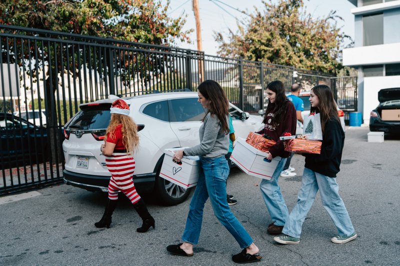 Volunteers carry donations of gifts, clothing, and more during the annual Adopt-a-Family LA distribution event on Dec. 13 at the Cathedral of Our Lady of the Angels. (Peter Lobato)
