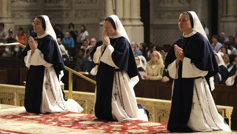 Sisters of Life Maria Augustine, left, Leonie Therese and Beata Victoria kneel in the sanctuary during Mass at St. Patrick's Cathedral in New York City Aug. 6, 2025. The three women religious professed their perpetual vows during the liturgy. (OSV News/Gregory A. Shemitz)