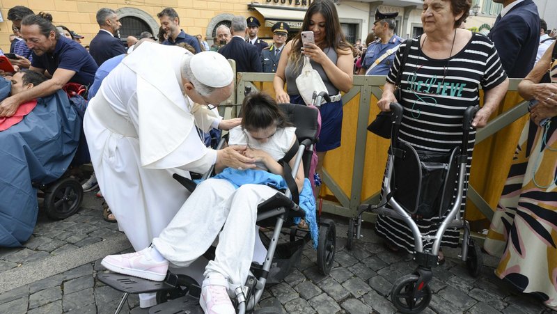 Pope Leo XIV greets a young woman in a wheelchair after leading the recitation of the Angelus prayer in front of the papal palace in Castel Gandolfo, Italy, Aug. 17, 2025. (CNS photo/Vatican Media)