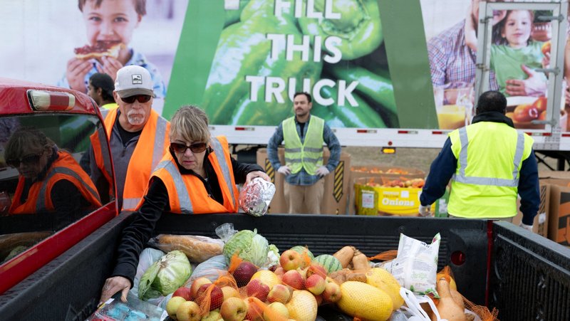 Volunteers Craig and Caroline Harvey place food items in a truck bed during a mobile food distribution at Cedar Creek High School, as nearly 42 million Americans face a potential lapse in Supplemental Nutrition Assistance Program (SNAP), a food support program, due to the longest U.S. government shutdown, in Cedar Creek, Texas, Nov. 1, 2025. (OSV News photo/Kaylee Greenlee, Reuters)