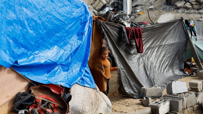 A displaced Palestinian child looks on from a tent near the rubble of residential buildings destroyed during the war, on New Year's Eve in Jabalia, northern Gaza Strip, Dec. 31, 2025. Israel on Dec. 30 said it had suspended operations of more than two dozen humanitarian organizations, including, including Caritas. (OSV News photo/Mahmoud Issa, Reuters)