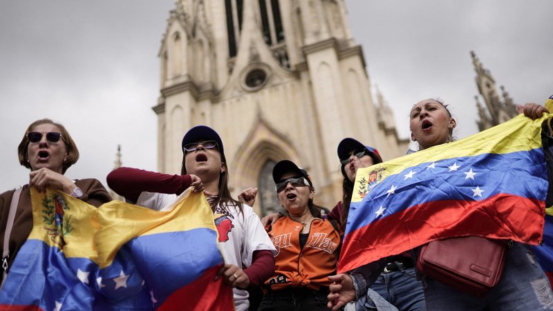 People hold Venezuelan flags as Venezuelans living in Colombia demonstrate in front of of the Minor Basilica of Our Lady of Lourdes in Bogota Jan. 4, 2026, for a democratic transition, after the U.S. launched strikes on Venezuela, capturing its President Nicolas Maduro and his wife Cilia Flores. (OSV News photo/Sergio Acero, Reuters)