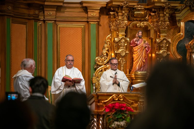 Father Gilbert Guzman, pastor of Sacred Heart Church in Altadena, presides over a Jan. 7 healing Mass on the one-year anniversary of the Eaton Fire. To his right is Deacon José Luis Díaz, who helped save the parish from burning. (John Rueda)