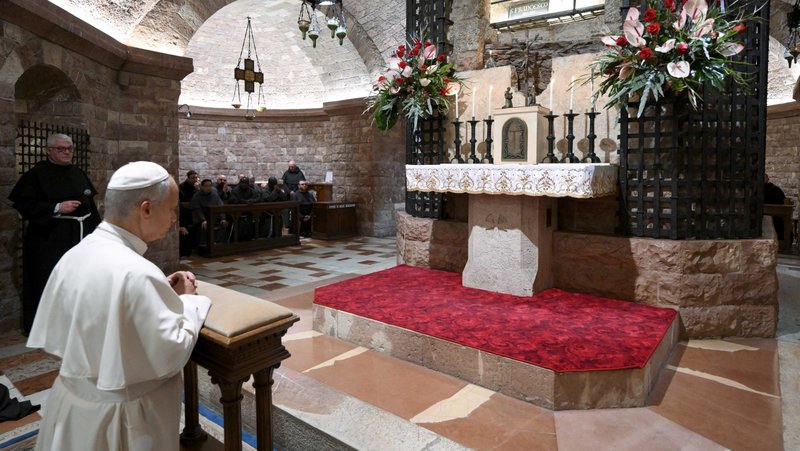 Pope Leo XIV and Franciscan friars pray before the tomb of St. Francis in the Basilica of St. Francis of Assisi, Italy, Nov. 20, 2025. (CNS photo/Vatican Media)