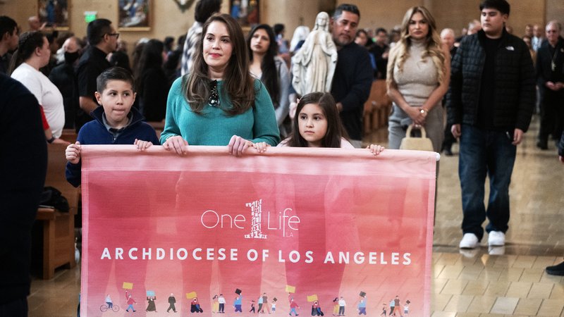 The Gonzalez and Magallon families, who both lost their homes in the Eaton Fire, process into the Cathedral of Our Lady of the Angels to begin the OneLife LA event on Jan. 18, 2025. (Victor Alemán)