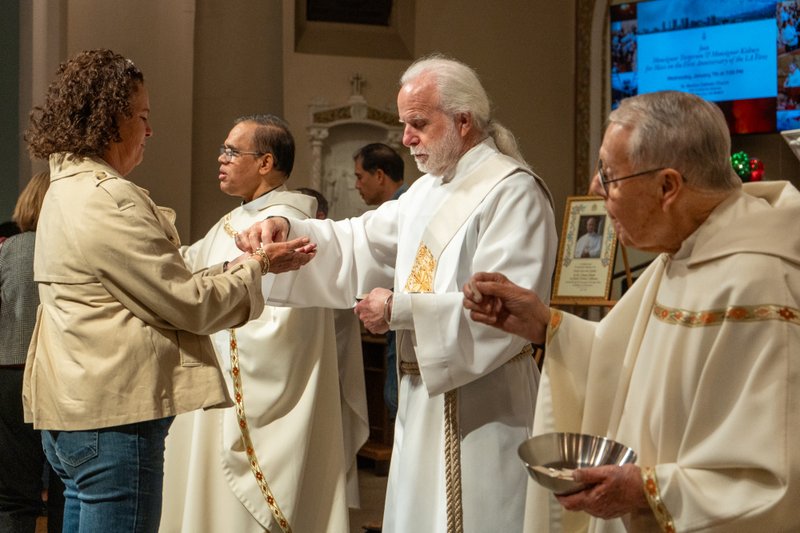 Parishioners receive Communion at St. Monica Church in Santa Monica during a Jan. 7 Mass on the one-year anniversary of the Palisades Fire that burned down Corpus Christi Church. (Elizabeth Friedrich)