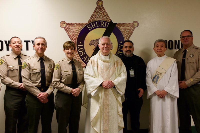 Auxiliary Bishop Matt Elshoff poses with sheriff's deputies and others as he celebrated Christmas Day Mass with inmates at Men’s Central Jail near downtown LA. (Reese Cuevas)