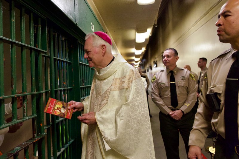 Bishop Matthew Elshoff handed out copies of the St. Carlo Acutis-inspired book “3 Days to Eucharistic Fire” to inmates after celebrating Christmas Day Mass at Men’s Central Jail near downtown LA. (Reese Cuevas)