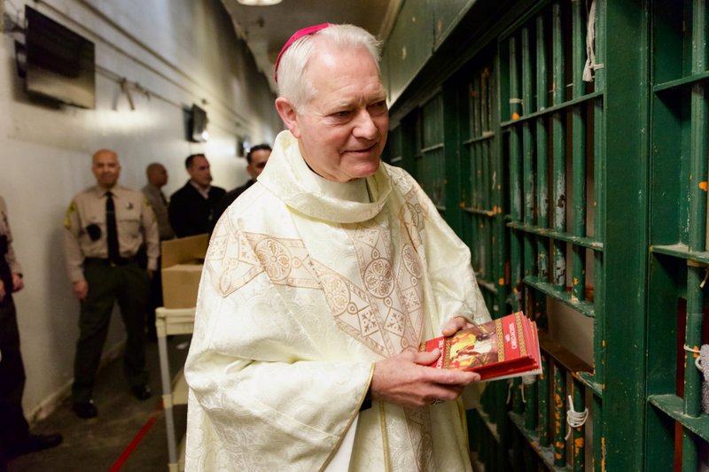 Bishop Matthew Elshoff handed out copies of the St. Carlo Acutis-inspired book “3 Days to Eucharistic Fire” to inmates after celebrating Christmas Day Mass at Men’s Central Jail near downtown LA. (Reese Cuevas)