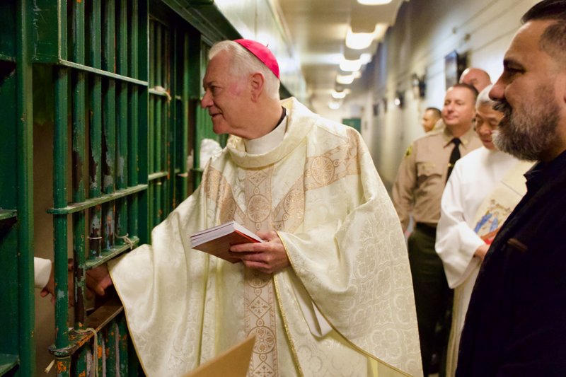 Bishop Matthew Elshoff handed out copies of the St. Carlo Acutis-inspired book “3 Days to Eucharistic Fire” to inmates after celebrating Christmas Day Mass at Men’s Central Jail near downtown LA. (Reese Cuevas)