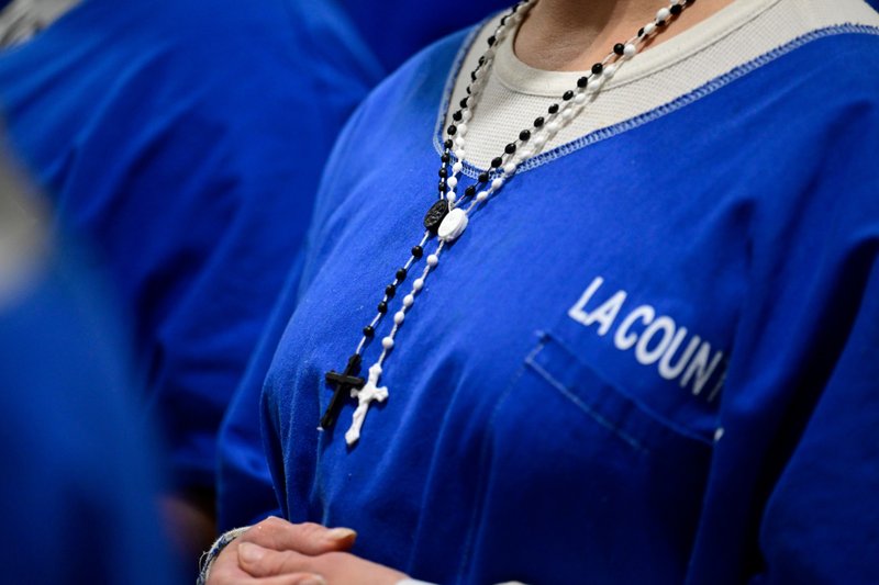 An inmate wears crosses during Mass at Century Regional Detention Facility in Lynwood, LA County’s largest women’s jail, on Christmas Day, Dec. 25, 2025. (John McCoy)