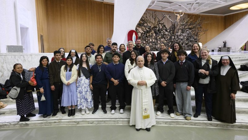 The senior class at Holy Innocents School in Long Beach, Calif., pose with Pope Leo XIV and other members of their group following the pope's general audience in the Paul VI Audience Hall at the Vatican Feb. 11, 2026. The school group met Pope Leo less than two weeks after their school was found vandalized and desecrated Feb. 2.(OSV News photo/Vatican Media via CPP)