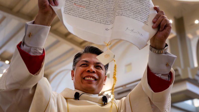 Auxiliary Bishop Peter Dai Bui displays the papal bull during his ordination and installation Mass as a Phoenix auxiliary at St. Thomas Aquinas Church in Avondale, Ariz., Feb. 17, 2026. Bishop Bui, originally from Vietnam, joins Phoenix Auxiliary Bishop Eduardo A. Nevares in serving with Phoenix Bishop John P. Dolan. (OSV News photo/Brett Meister, courtesy Diocese of Phoenix)