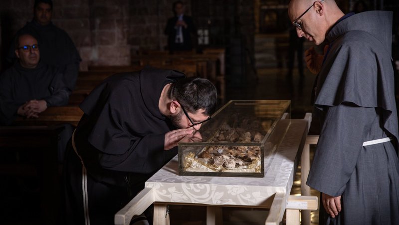 A monk from the local Franciscan community venerates the relics of St. Francis, which were exhumed from their shrine in the Basilica of St. Francis in Assisi, Italy, the morning of Feb. 21, 2026. The remains were exhumed in the presence of the friars and placed on a specially prepared table in the crypt, before being displayed for public veneration, which began Feb. 22 and runs through March 22. (OSV News photo/courtesy Sala Stampa Sacro Convento Assisi)
