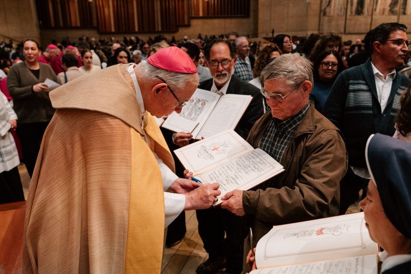 Archbishop José H. Gomez signs a parish’s Book of the Elect during the Rite of Election ceremony at the Cathedral of Our Lady of the Angels on Feb. 15. (Peter Lobato)