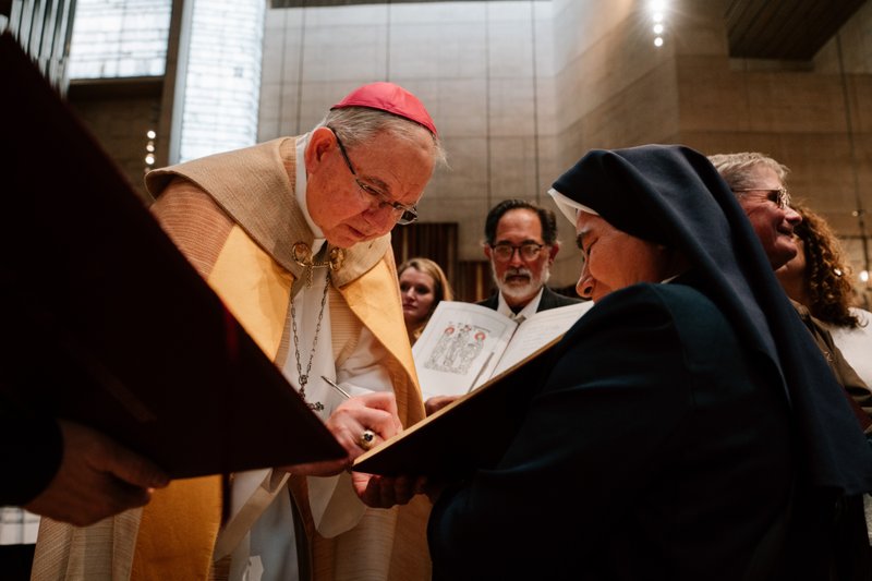 Archbishop José H. Gomez signs a parish’s Book of the Elect during the Rite of Election ceremony at the Cathedral of Our Lady of the Angels on Feb. 15. (Peter Lobato)