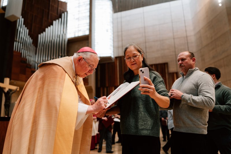Archbishop José H. Gomez signs a parish’s Book of the Elect during the Rite of Election ceremony at the Cathedral of Our Lady of the Angels on Feb. 15. (Peter Lobato)