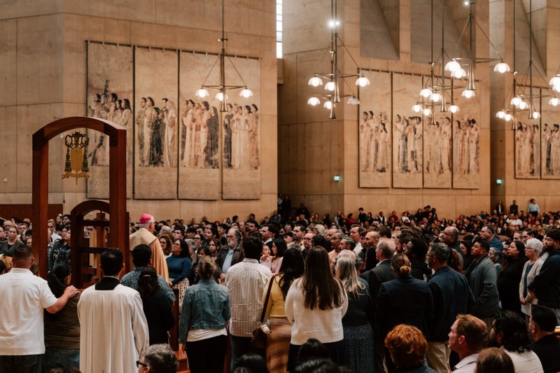 Archbishop José H. Gomez stands in the throng of catechists and catechumens on the altar with the Book of the Elect during the Rite of Election ceremony at the Cathedral of Our Lady of the Angels on Feb. 15. (Peter Lobato)