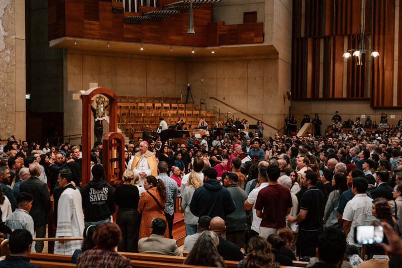 Archbishop José H. Gomez stands in the throng of catechists and catechumens on the altar with the Book of the Elect during the Rite of Election ceremony at the Cathedral of Our Lady of the Angels on Feb. 15. (Peter Lobato)