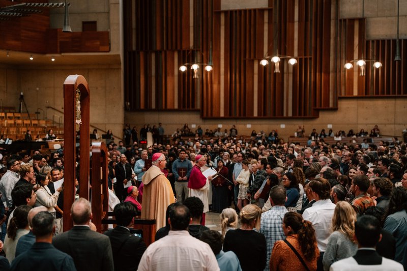 Archbishop José H. Gomez stands in the throng of catechists and catechumens on the altar with the Book of the Elect during the Rite of Election ceremony at the Cathedral of Our Lady of the Angels on Feb. 15. (Peter Lobato)