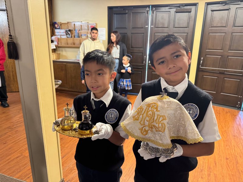 St. Paul of the Cross School students Jian Tubiera, left, and Logan Cordova, right, help during Mass during Catholic Schools Week. (St. Paul of the Cross School)