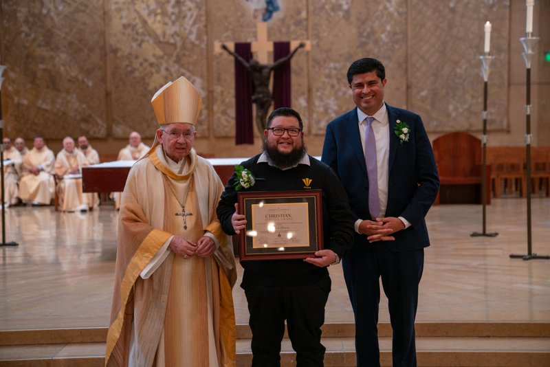 Archbishop José H. Gomez and Paul Escala, superintendent of LA Catholic schools, pose with Verbum Dei High School's Kevin Garcia at the 2026 Christian Service Awards Mass on March 10 at the Cathedral of Our Lady of the Angels. (John Rueda)