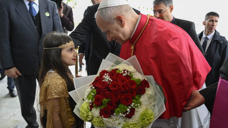 Pope Leo XIV is greeted by an Algerian girl with flowers upon arrival at Houari Boumediene International Airport in Dar El Beida district in Algiers, Algeria, April 13, 2026, to begin his apostolic journey to Algeria, Angola, Cameroon and Equatorial Guinea. (OSV News photo/Simone Risoluti, Vatican Media)