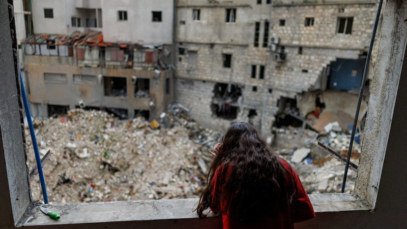 Alaa Dahnoun, 12, who said she survived an Israeli strike that forced her to flee with her parents to Beirut, looks out through her apartment's damaged window in Nabatieh, Lebanon, April 18, 2026, after a 10-day ceasefire between Lebanon and Israel went into effect. (OSV News photo/Zohra Bensemra, Reuters)